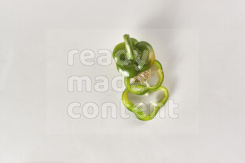 Green bell pepper slices on white background