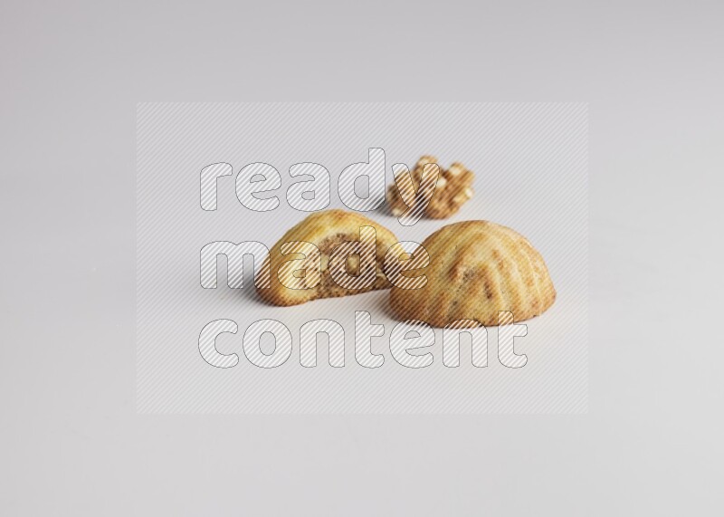 Two Pieces of Maamoul filled with walnut paste  one of them is cut direct on white background