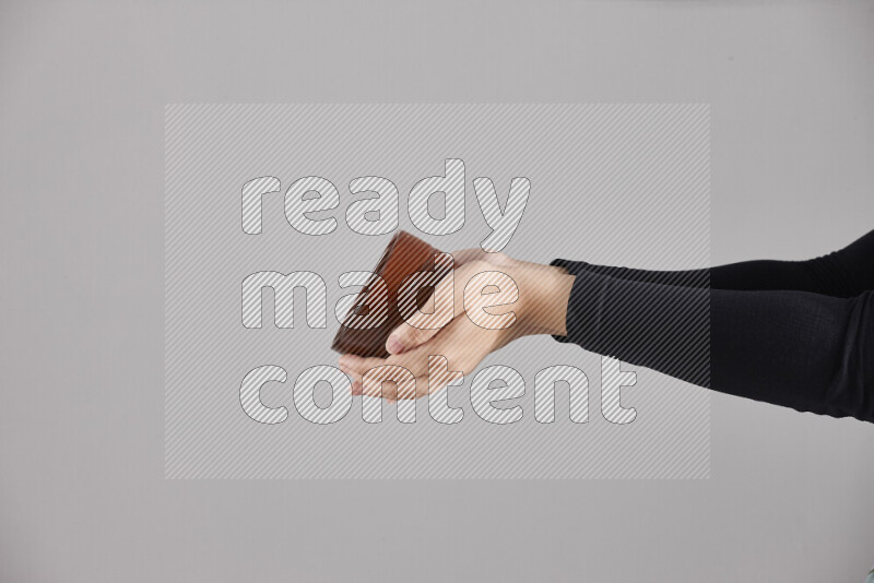 A woman in black abaya holding different pottery essentials in different positions