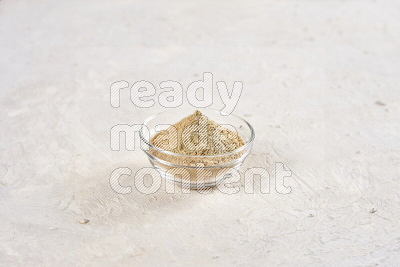 A glass bowl full of ground ginger powder on white background