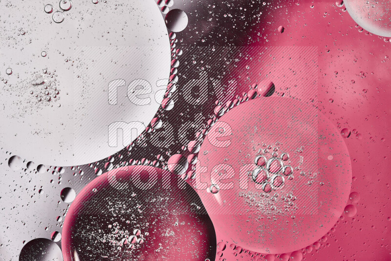 Close-ups of abstract oil bubbles on water surface in shades of white and pink