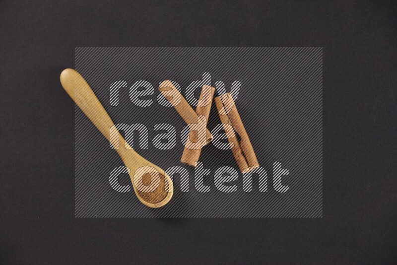 3 Cinnamon sticks stacked beside a wooden spoon full of cinnamon powder on black background in different angles