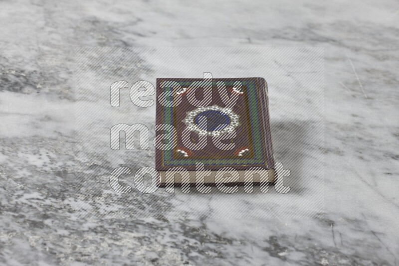 Quran with a prayer beads on grey marble background