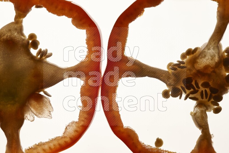 Red bell pepper slices on illuminated white background