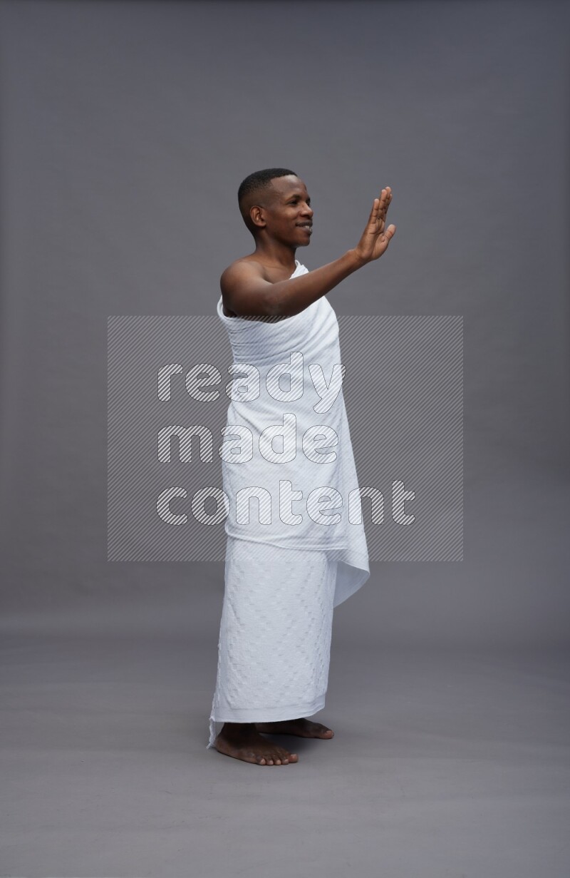 A man wearing Ehram Standing Interacting with the camera on gray background