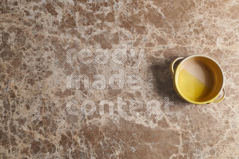 A multicolored pottery bowl on beige marble background