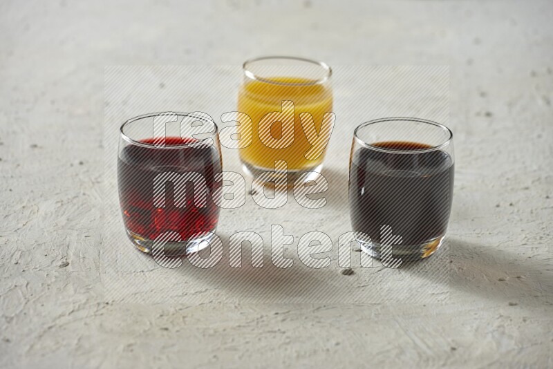 Cold drinks in a glass cup such as water, tamarind, qamar eldin, sobia, milk and hibiscus on textured white background