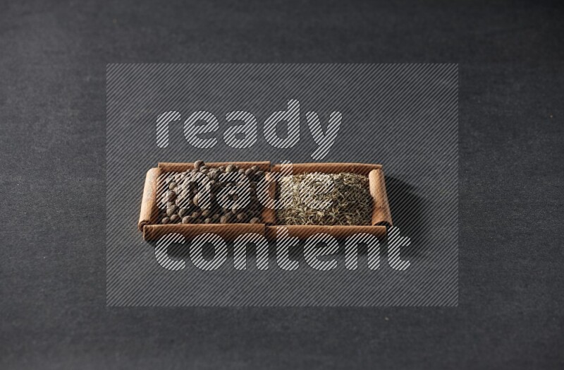 2 squares of cinnamon sticks full of cumin and allspice on black flooring