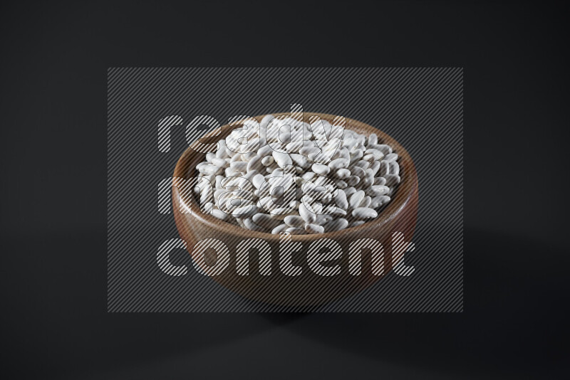 Snacks in a wooden bowl on grey background