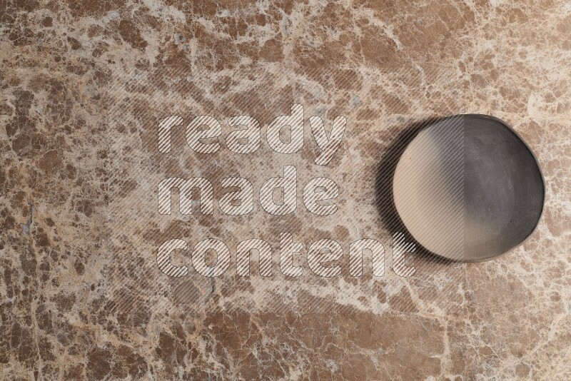 A multicolored pottery plate on beige marble background