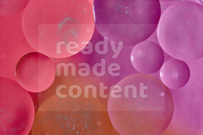 لقطات مقربة لفقاعات من الزيت على سطح الماء باللون الأحمر والبرتقالي والوردي