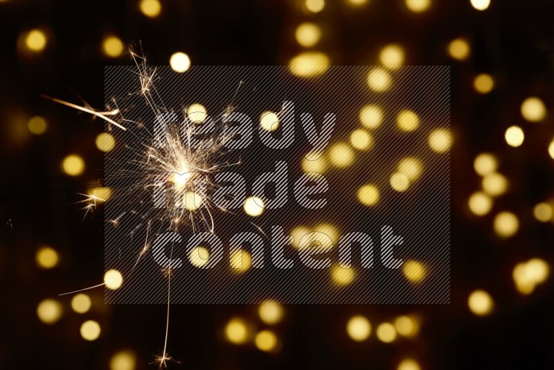 Sparkler candle with yellow light bokeh background
