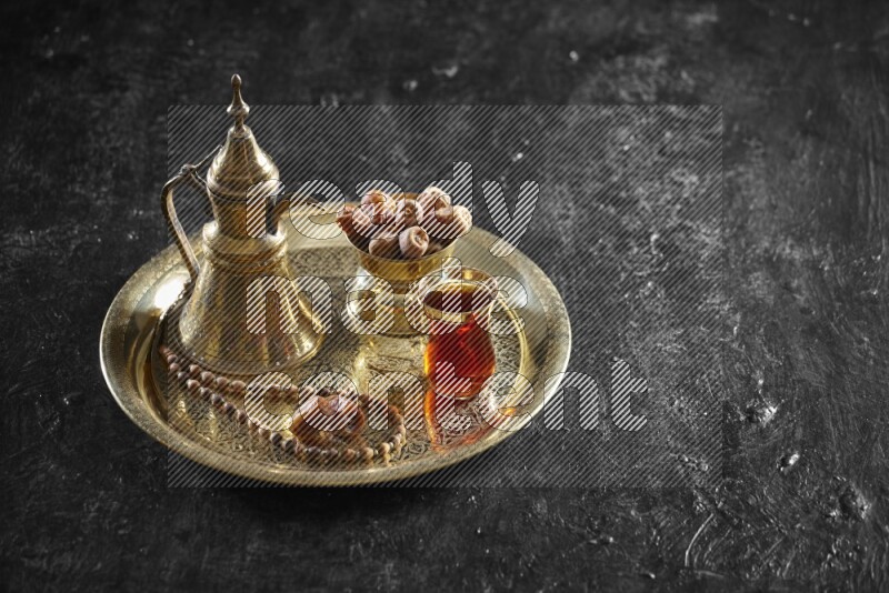 Dates with a drink on a metal tray in a dark setup