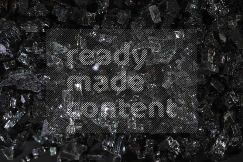 Transparent black fragments of glass scattered on a black background