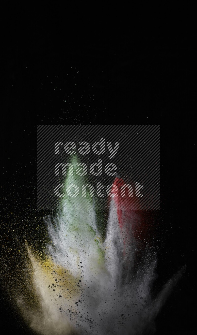 A side view of multicolored powder explosion on black background