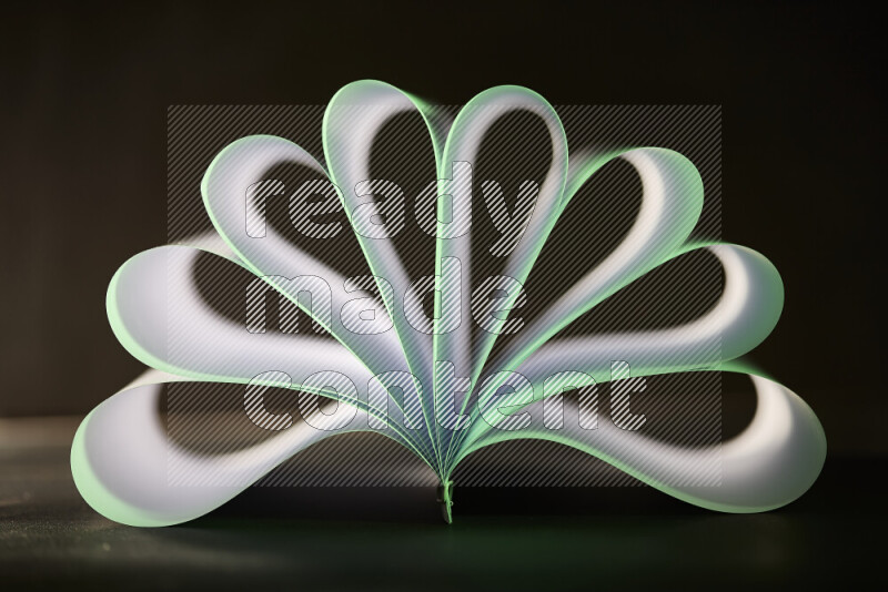An abstract art piece displaying smooth curves in green and white gradients created by colored light