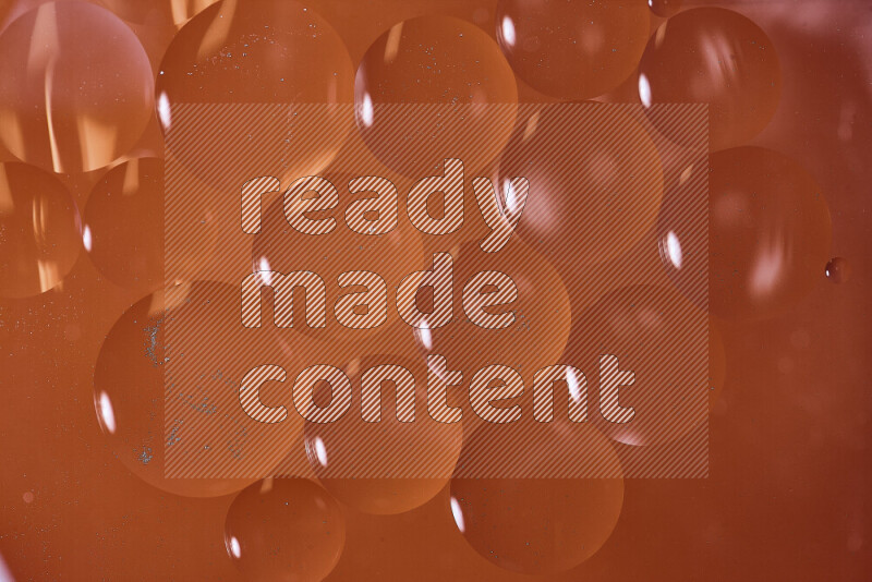 لقطات مقربة لفقاعات من الزيت على سطح الماء باللون البرتقالي