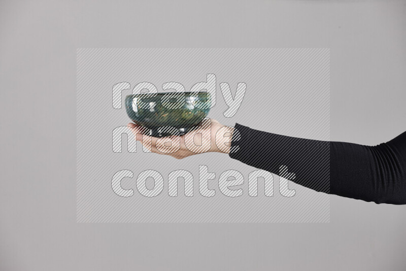 امرأة ترتدي عباءة سوداء تحمل أدوات فخارية مختلفة في أوضاع متعددة