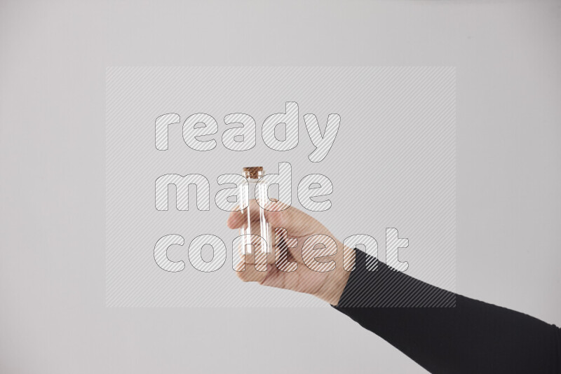 امرأة ترتدي عباءة سوداء تحمل أدوات زجاجية مختلفة في أوضاع متعددة