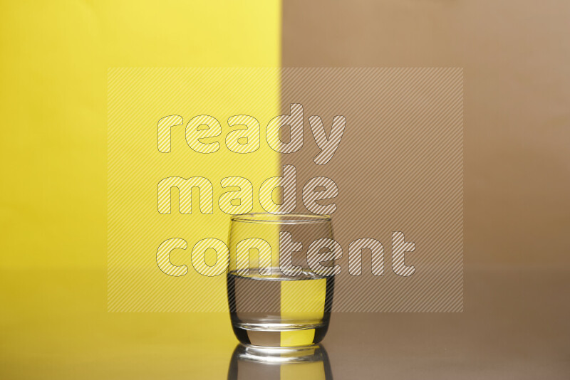 The image features a clear glassware filled with water, set against yellow and beige background