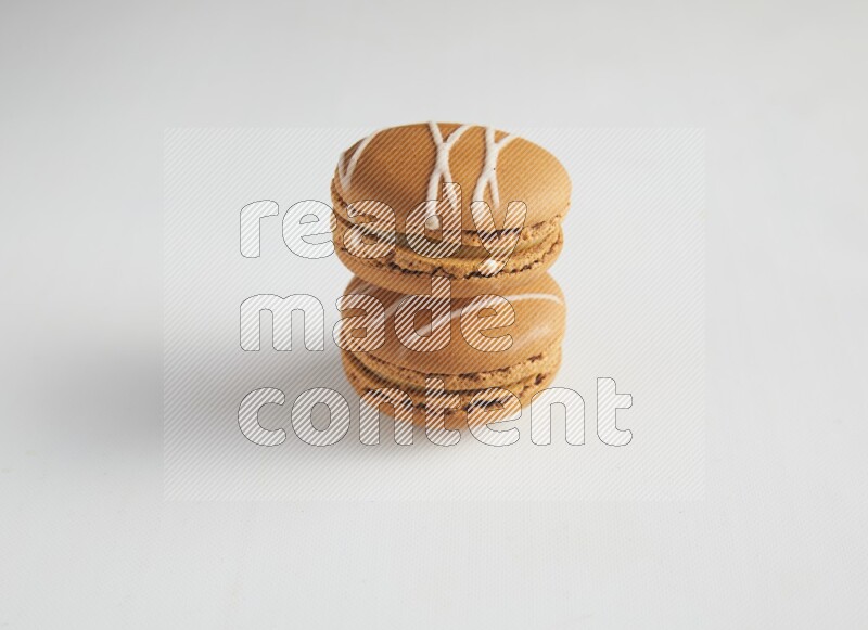 45º Shot of two Brown Irish Cream macarons on white background