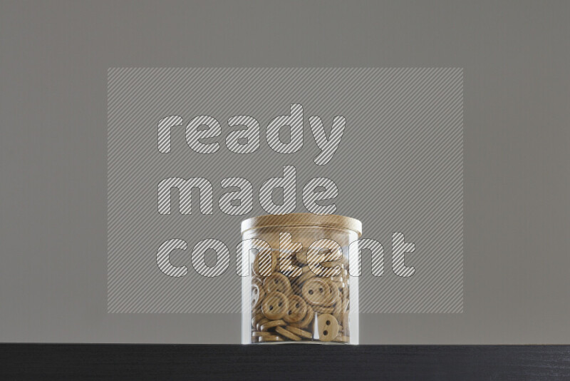 Buttons in a glass jar on black background