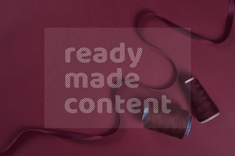 مجموعة من أدوات الخياطة والتفصيل حمراء اللون على خلفية حمراء