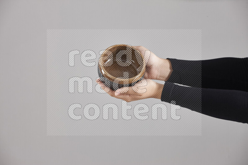 A woman in black abaya holding different pottery essentials in different positions