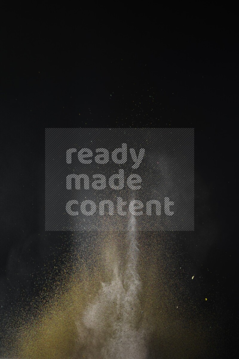 A side view of brown powder explosion on black background