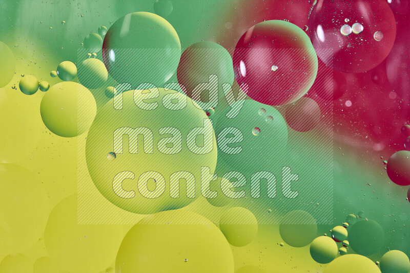 Close-ups of abstract oil bubbles on water surface in shades of yellow, red and green