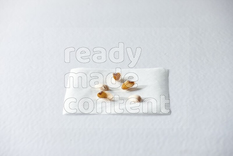 Pistachio peels on a piece of paper on a white background in different angles