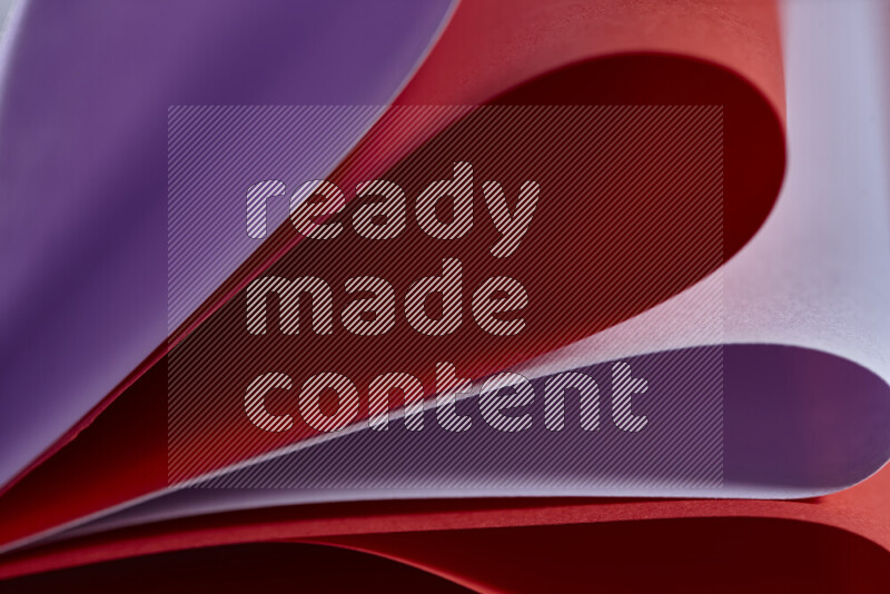 An abstract art showing purple and red paper sheets arranged in an overlapping curves