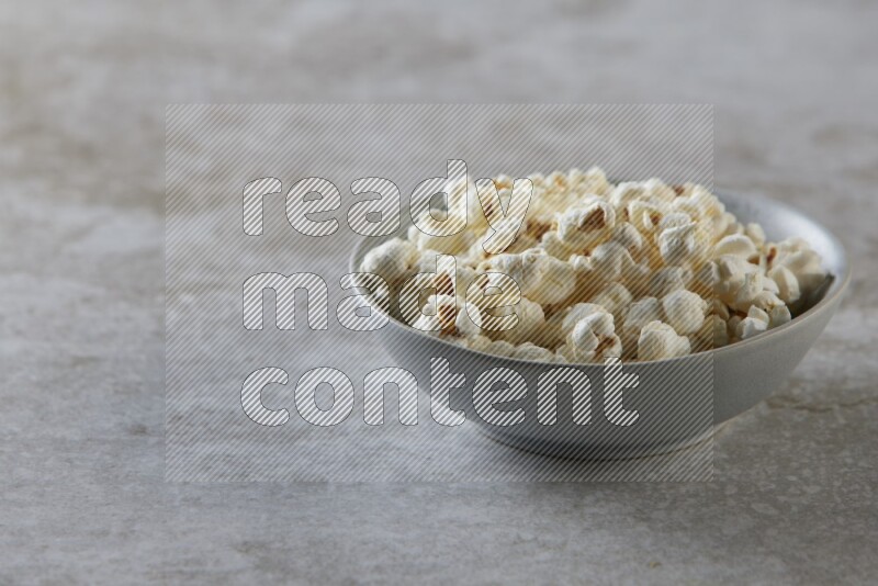 popcorn in gray bowl on a grey textured countertop