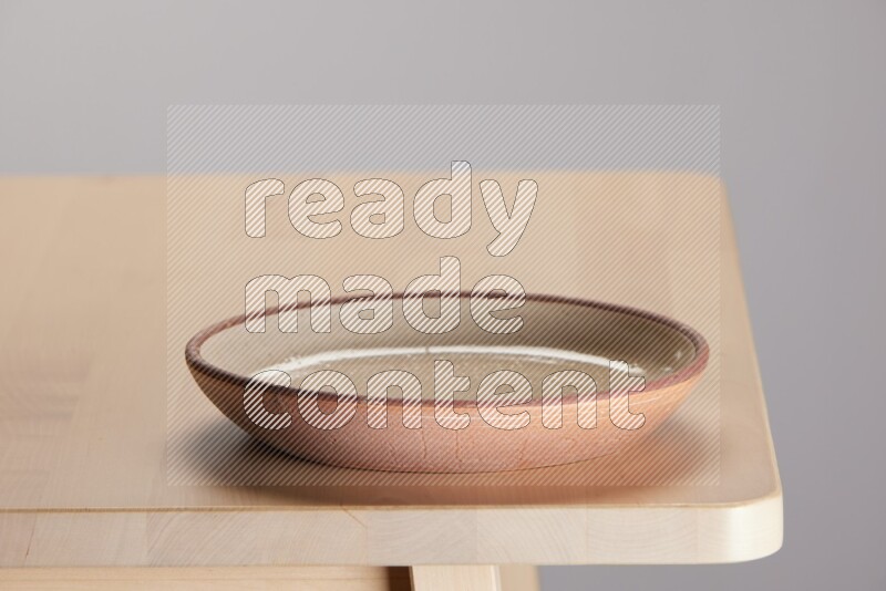 multi-colored pottery Plate on a wooden table edge