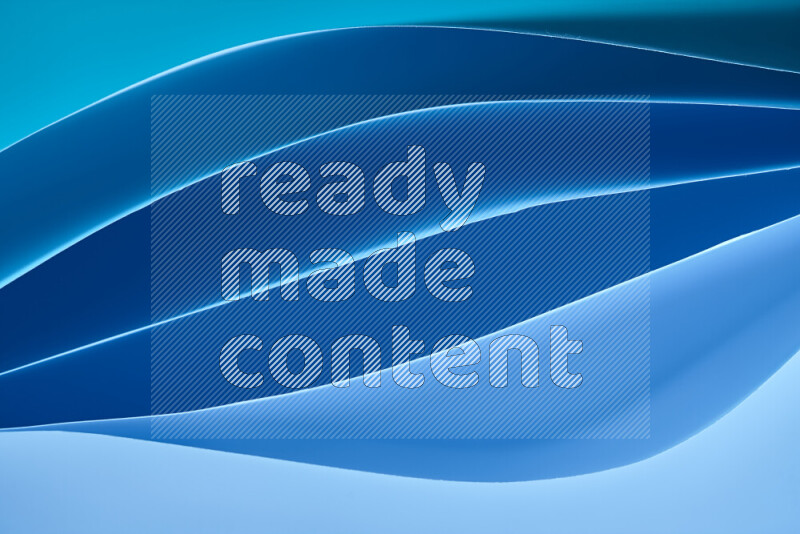 This image showcases an abstract paper art composition with paper curves in blue gradients created by colored light