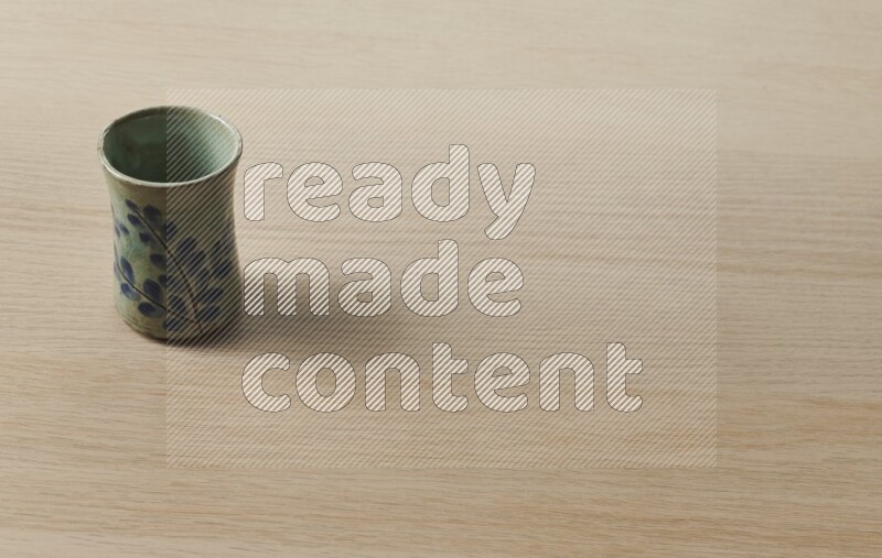 A pottery cup on light wooden background