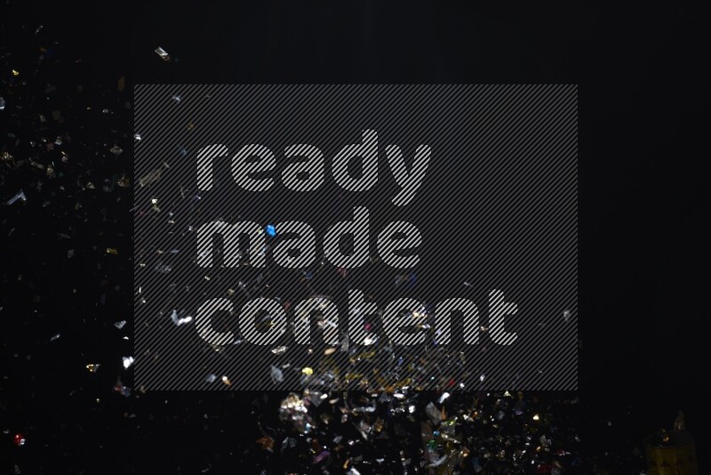 Falling multicolored confetti on black background