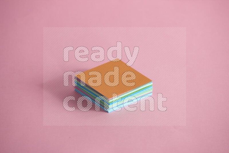 Stacked multicolored sticky notes on rose background