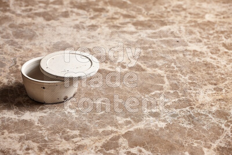 A white pottery bowl on beige marble background