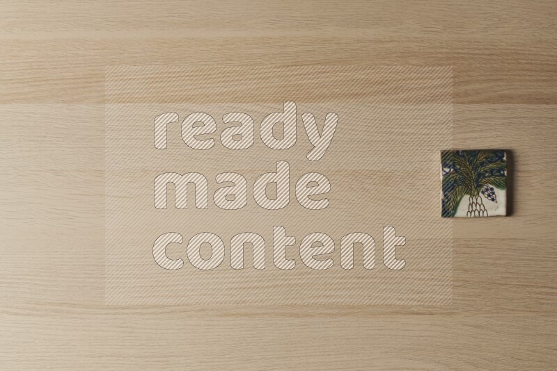 A decorative pottery coaster on light wooden background