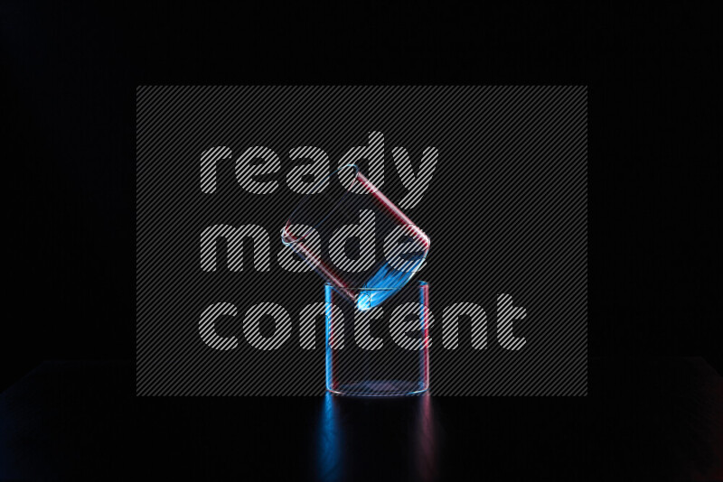 Glassware with rim light in red and blue against black background
