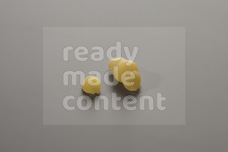 Shells pasta with other types of pasta on grey background