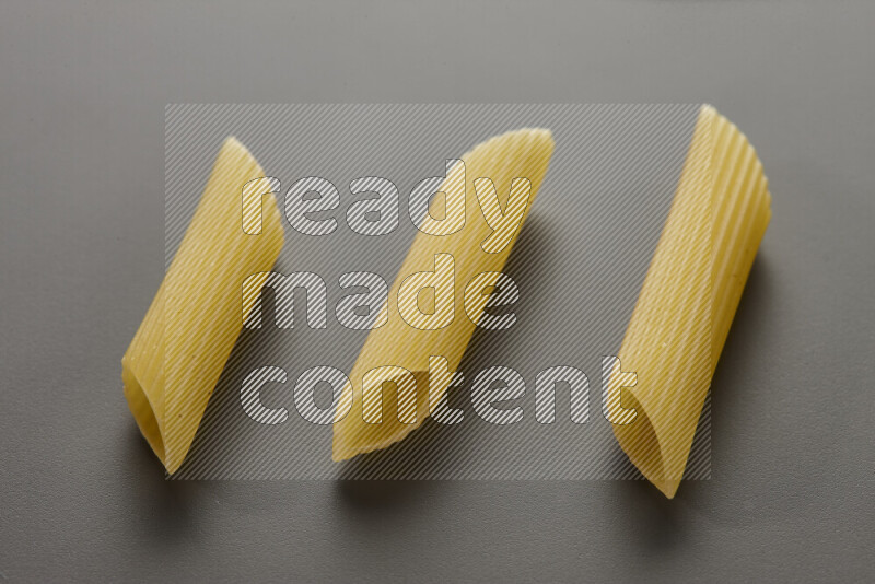 Penne pasta on grey background