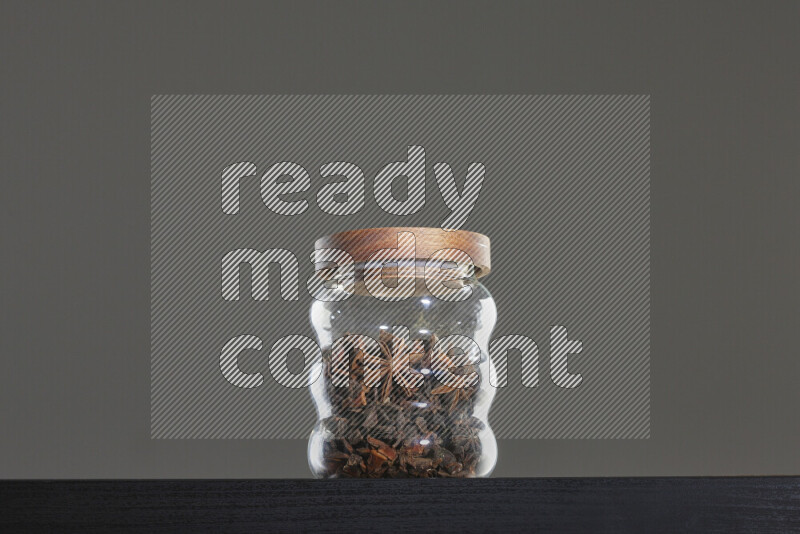 Star anise in a glass jar on black background