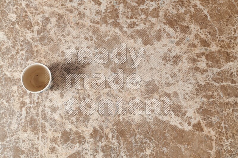 A pottery cup on beige marble background