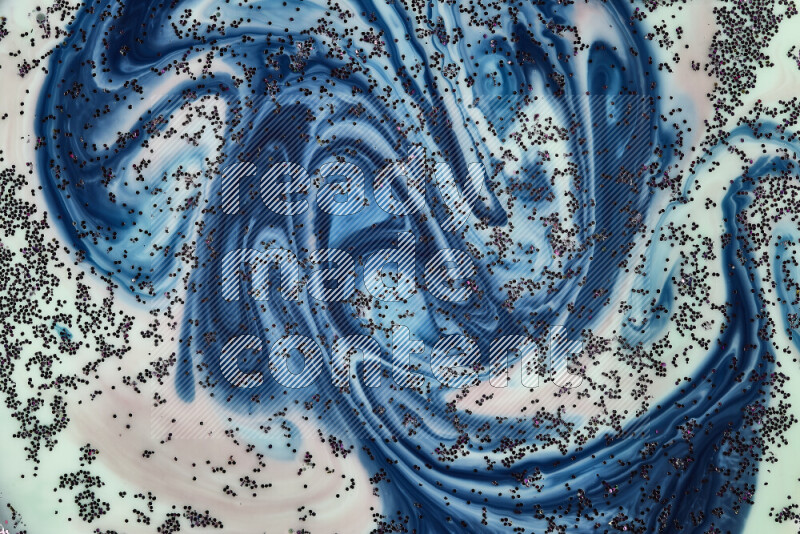 A close-up of sparkling purple glitter scattered on swirling green, red and blue background