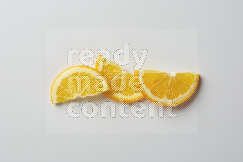 Three halves of an orange slices on white background