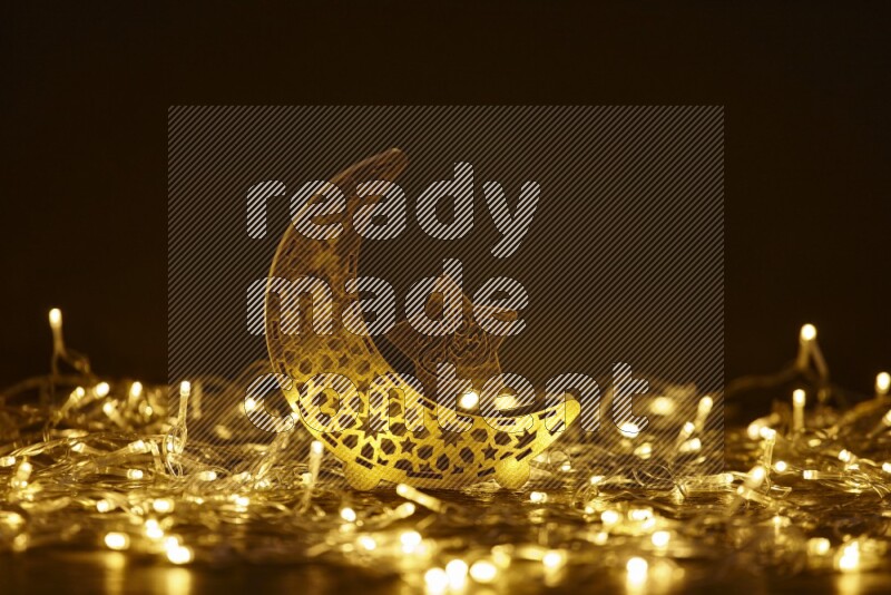 A traditional ramadan lantern surrounded by glowing fairy lights in a dark setup