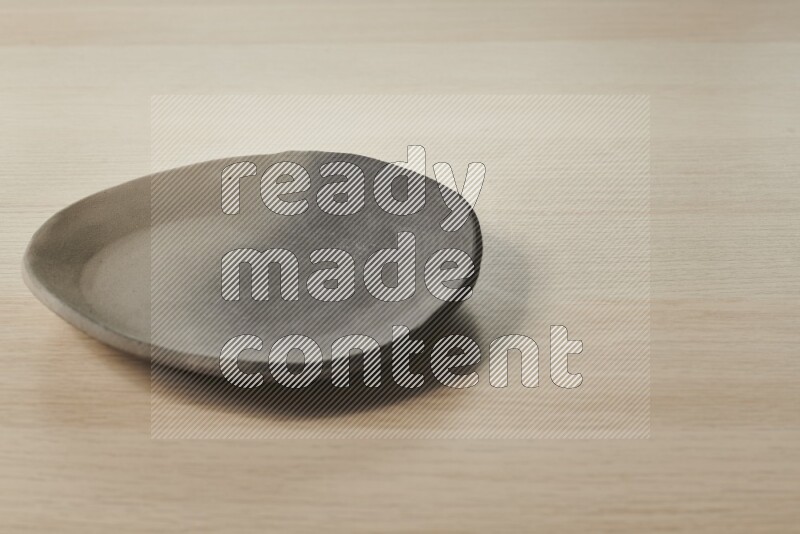 A multicolored pottery plate on light wooden background