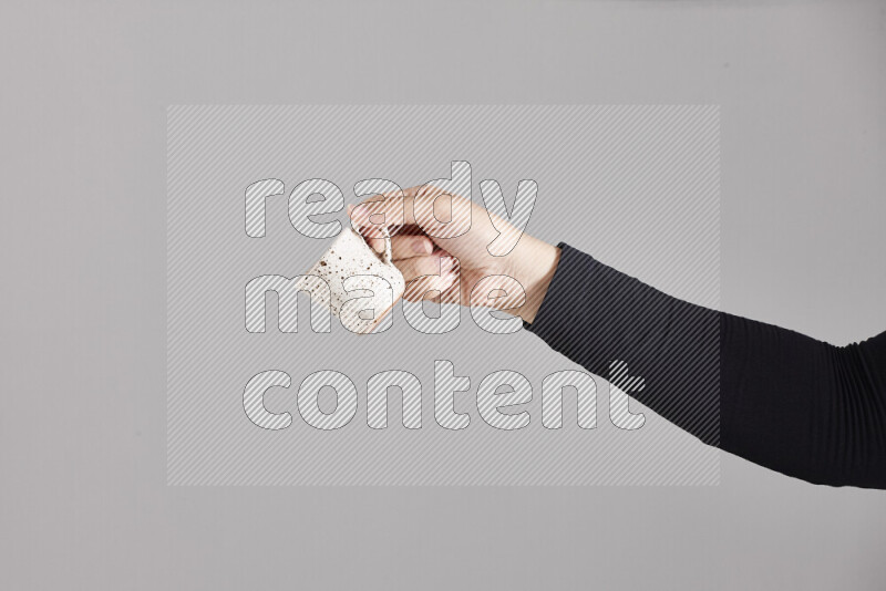 A woman in black abaya holding different pottery essentials in different positions